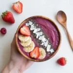 Gesunde Schale mit frischen Früchten, Nüssen und Beeren auf hellem Untergrund