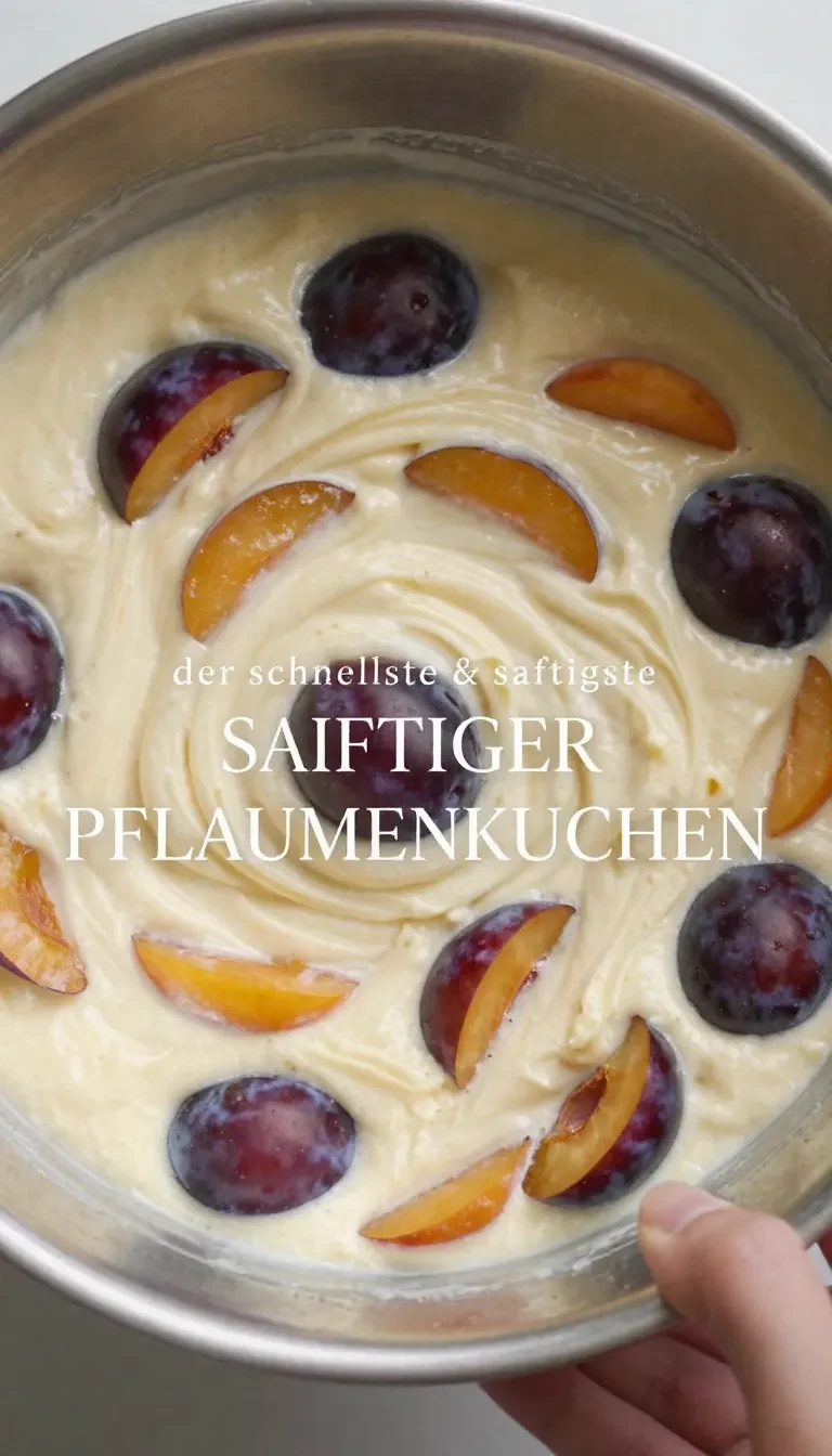 Ein Stück frisch gebackener Pflaumenkuchen mit goldbraunem Boden und saftigen Pflaumen auf einem weißen Teller.